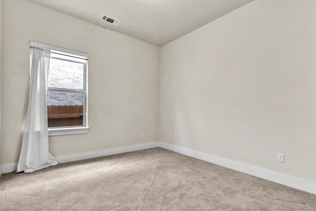 carpeted empty room featuring baseboards