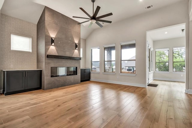 unfurnished living room featuring baseboards, light wood-style floors, a ceiling fan, and lofted ceiling