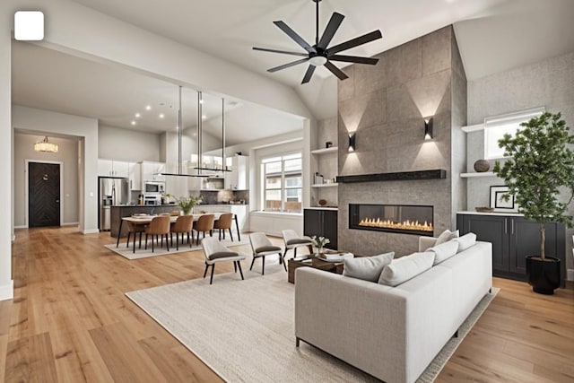 living area with light wood-style floors, a tile fireplace, a ceiling fan, baseboards, and recessed lighting