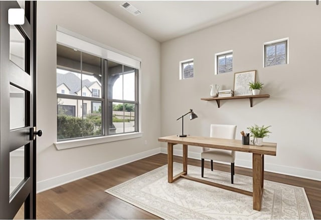 office area with plenty of natural light, baseboards, and dark wood-type flooring