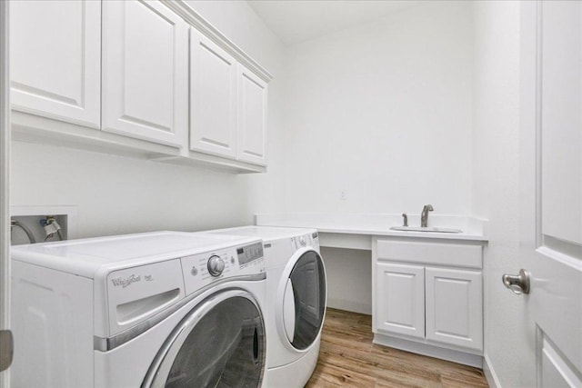 5701 Cherokee Draw Rd, Austin, TX 78738 - laundry room with cabinet space, washing machine and clothes dryer, and light wood-style floors