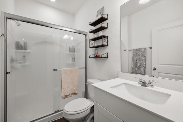 full bathroom featuring toilet, vanity, and a stall shower