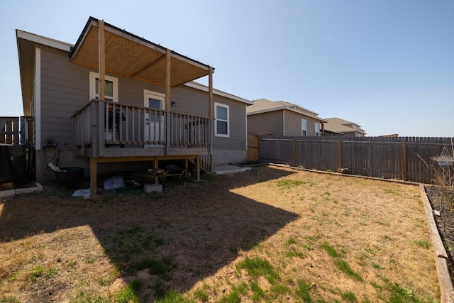 rear view of house featuring a fenced backyard and a wooden deck