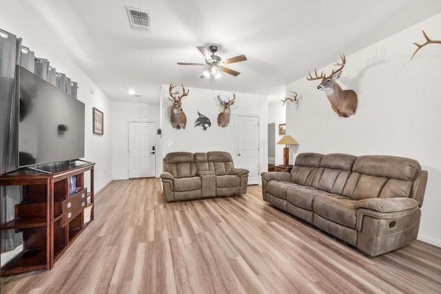 living area featuring light wood-style floors, ceiling fan, and visible vents