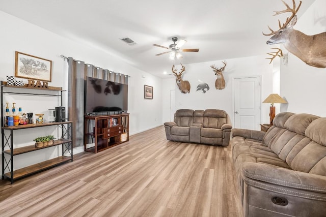 living area with visible vents, wood finished floors, and a ceiling fan
