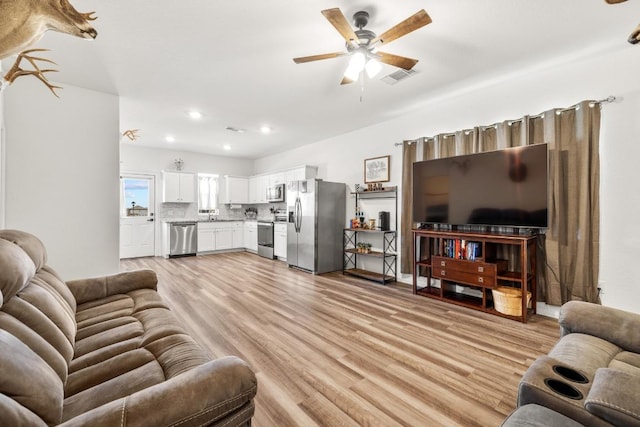 living room with a ceiling fan, recessed lighting, light wood finished floors, and visible vents