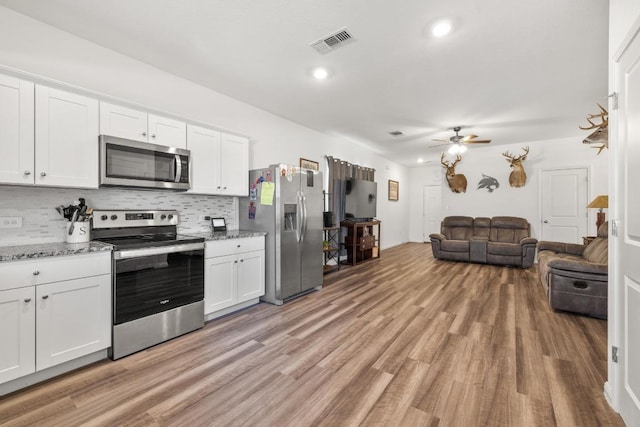 kitchen featuring light wood finished floors, appliances with stainless steel finishes, open floor plan, visible vents, and ceiling fan