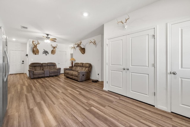 living area with ceiling fan, visible vents, and light wood finished floors