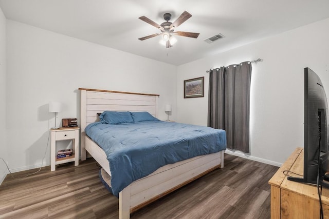 bedroom with a ceiling fan, wood finished floors, baseboards, and visible vents