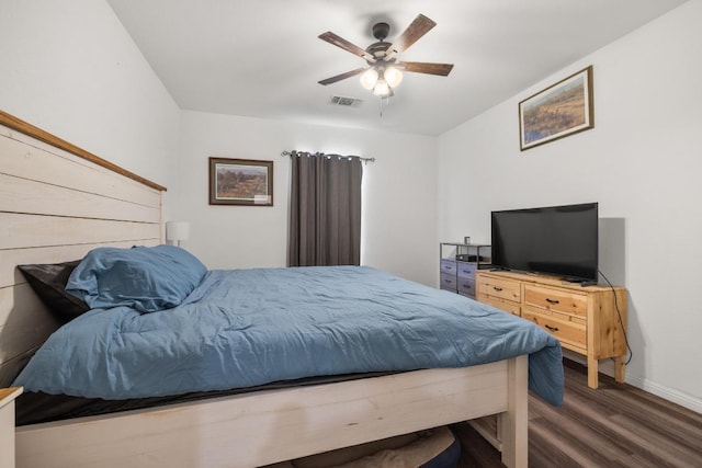 bedroom featuring baseboards, visible vents, a ceiling fan, and wood finished floors