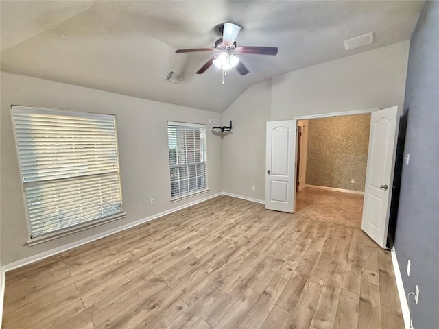 unfurnished bedroom with visible vents, light wood-style floors, baseboards, ceiling fan, and vaulted ceiling