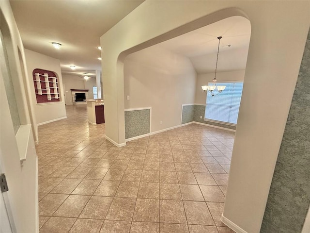 608 Pebblestone Walk Dr, Cedar Park, TX 78613 - empty room with light tile patterned floors, a chandelier, vaulted ceiling, a fireplace, and arched walkways