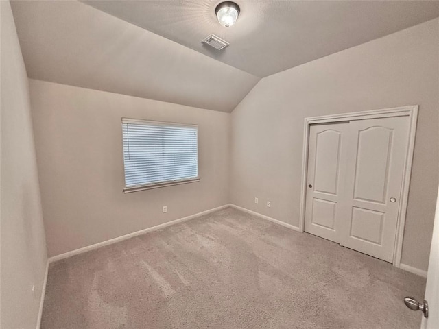 unfurnished bedroom with baseboards, carpet, and vaulted ceiling
