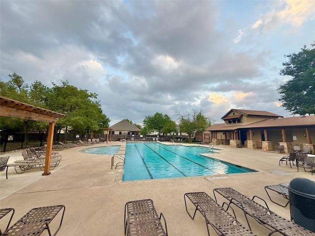 community pool featuring fence and a patio area