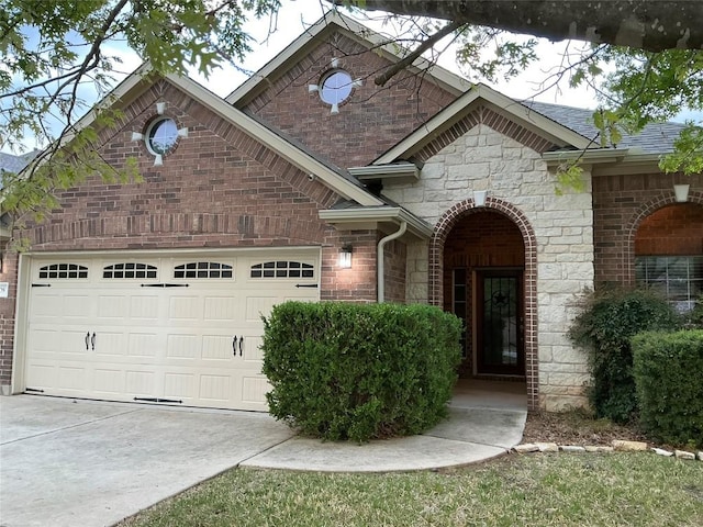 view of front of home featuring concrete driveway, an attached garage, a shingled roof, and stone siding