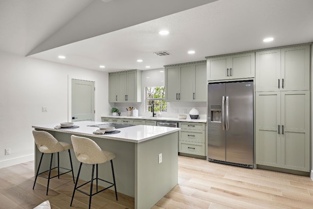 10418 Doc Holliday Trl, Austin, TX 78753 - kitchen with stainless steel appliances, a kitchen island, light wood-style floors, light countertops, and recessed lighting