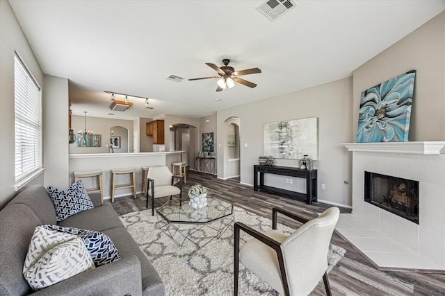 1606 Belvedere Pl, Round Rock, TX 78665 - living area featuring arched walkways, wood finished floors, a ceiling fan, and a tile fireplace