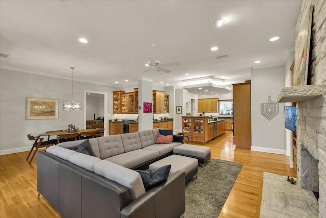 3208 Rain Dance Cv, Austin, TX 78746 - living room featuring ceiling fan, light wood-style floors, a stone fireplace, a chandelier, and recessed lighting