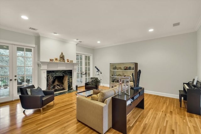 3208 Rain Dance Cv, Austin, TX 78746 - living room featuring french doors, light wood-style flooring, crown molding, recessed lighting, and a fireplace