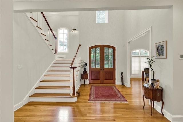 3208 Rain Dance Cv, Austin, TX 78746 - foyer featuring french doors, healthy amount of natural light, wood finished floors, stairs, and a high ceiling
