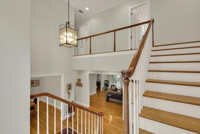3208 Rain Dance Cv, Austin, TX 78746 - staircase with wood finished floors, a chandelier, ornamental molding, and a high ceiling