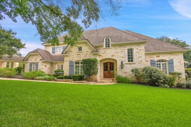 3208 Rain Dance Cv, Austin, TX 78746 - view of front of home featuring stone siding, a front lawn, and a tile roof