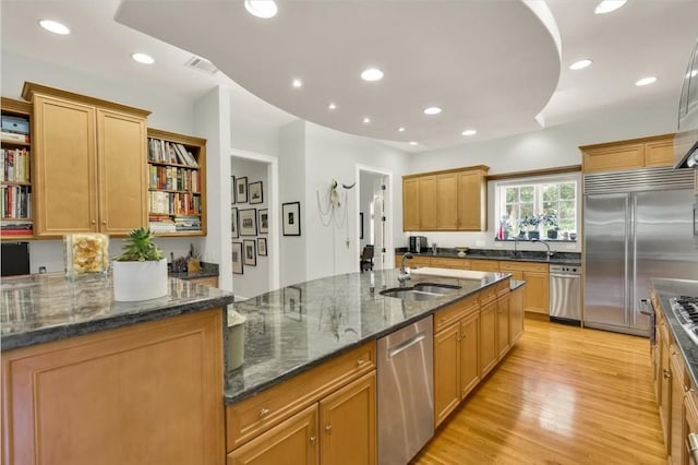 3208 Rain Dance Cv, Austin, TX 78746 - kitchen featuring appliances with stainless steel finishes, open shelves, light wood-style floors, dark stone counters, and recessed lighting