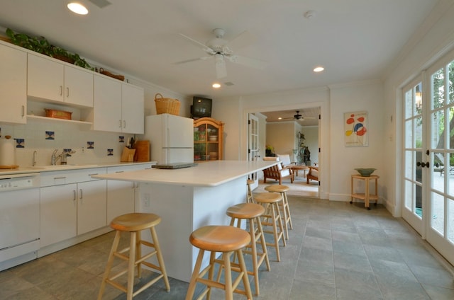3208 Rain Dance Cv, Austin, TX 78746 - kitchen featuring white appliances, a ceiling fan, a breakfast bar area, tasteful backsplash, and crown molding
