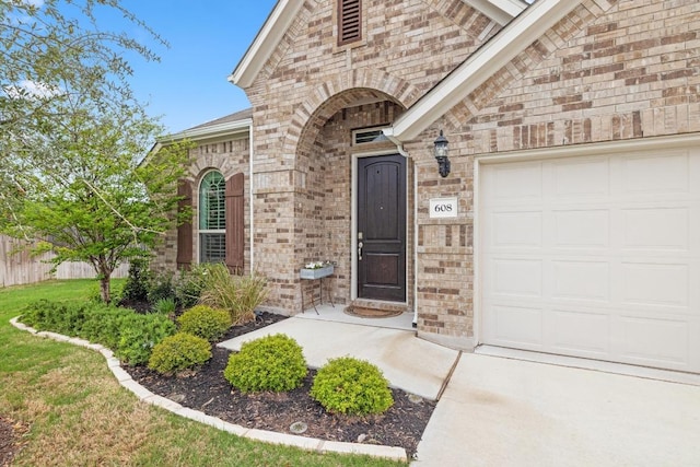 608 Roaming Dr, Hutto, TX 78634 - property entrance with an attached garage and brick siding