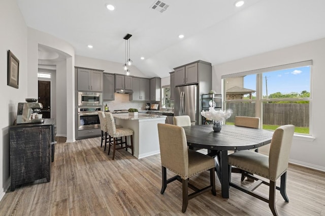 608 Roaming Dr, Hutto, TX 78634 - dining area with vaulted ceiling, light wood finished floors, and recessed lighting
