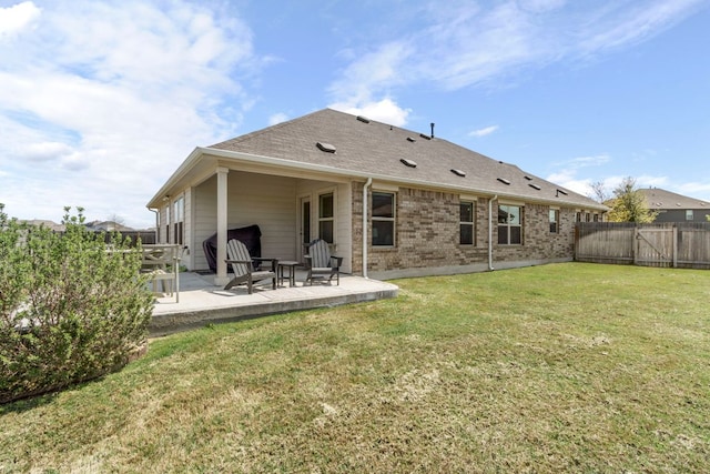 608 Roaming Dr, Hutto, TX 78634 - rear view of house with a patio, a fenced backyard, brick siding, and roof with shingles