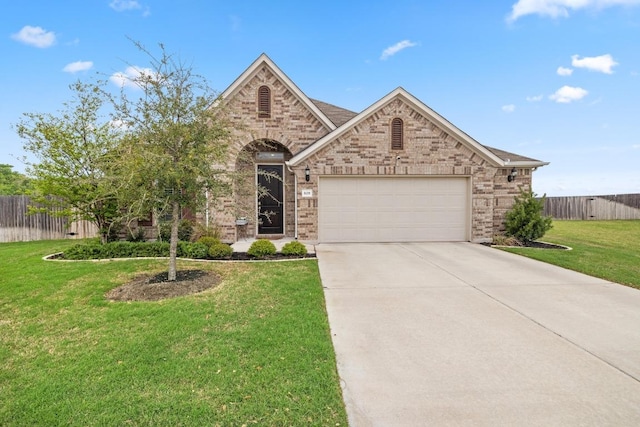 608 Roaming Dr, Hutto, TX 78634 - view of front facade with a garage, concrete driveway, and brick siding