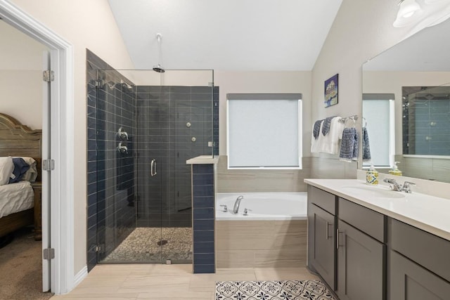 608 Roaming Dr, Hutto, TX 78634 - ensuite bathroom featuring vaulted ceiling, vanity, a garden tub, and a stall shower