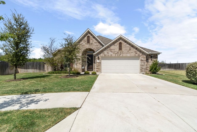 608 Roaming Dr, Hutto, TX 78634 - french country style house with concrete driveway, a garage, and stone siding