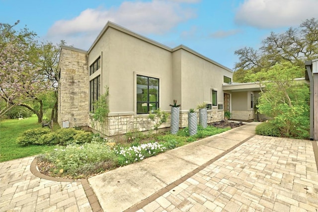 9206 Chisholm Ln, Austin, TX 78748 - view of side of home featuring stone siding and stucco siding