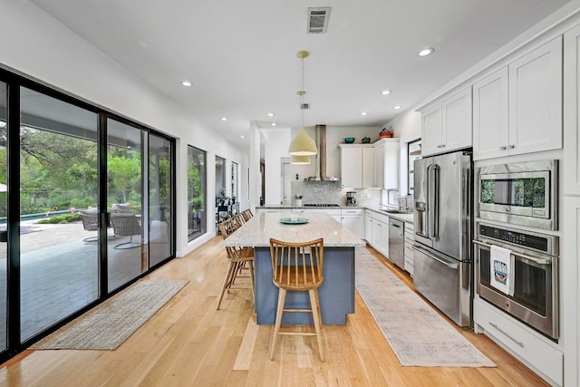9206 Chisholm Ln, Austin, TX 78748 - kitchen with appliances with stainless steel finishes, white cabinetry, light stone countertops, a center island, and backsplash