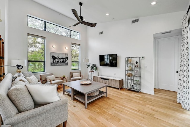 9206 Chisholm Ln, Austin, TX 78748 - living room with light wood-style floors, a ceiling fan, a towering ceiling, recessed lighting, and baseboards