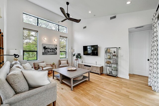 9206 Chisholm Ln, Austin, TX 78748 - living room with light wood-style flooring, ceiling fan, a high ceiling, and recessed lighting