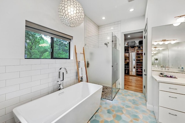 9206 Chisholm Ln, Austin, TX 78748 - bathroom with a stall shower, a spacious closet, vanity, a freestanding tub, and tile walls