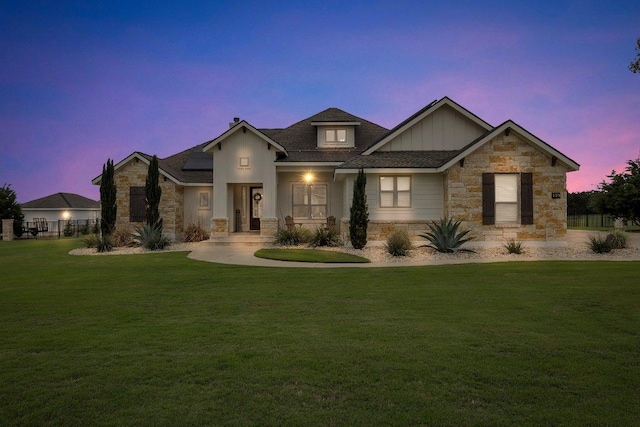 109 Spice Bush Spgs, Leander, TX 78641 - view of front of home featuring stone siding, board and batten siding, a lawn, and roof mounted solar panels