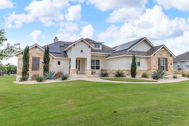 109 Spice Bush Spgs, Leander, TX 78641 - view of front facade with stone siding, board and batten siding, roof mounted solar panels, and a front yard