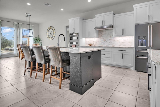 109 Spice Bush Spgs, Leander, TX 78641 - kitchen featuring appliances with stainless steel finishes, under cabinet range hood, recessed lighting, decorative backsplash, and a sink
