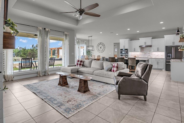 109 Spice Bush Spgs, Leander, TX 78641 - living room featuring a tray ceiling, ceiling fan, plenty of natural light, light tile patterned floors, and recessed lighting