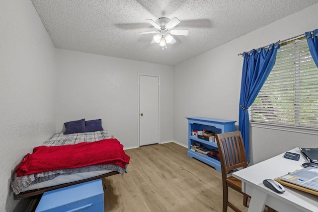 8410 Glen Canyon Dr, Round Rock, TX 78681 - bedroom with light wood-type flooring, a textured ceiling, and a ceiling fan