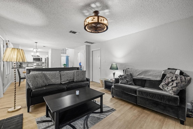 8410 Glen Canyon Dr, Round Rock, TX 78681 - living room with a textured ceiling and light wood-style floors
