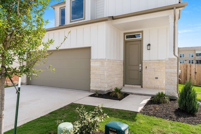 2201 Cento Walk Unit 70, Round Rock, TX 78664 - property entrance with board and batten siding, an attached garage, stone siding, and driveway