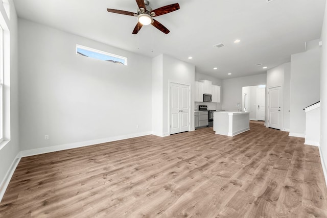 2201 Cento Walk Unit 70, Round Rock, TX 78664 - unfurnished living room with a ceiling fan, light wood finished floors, baseboards, recessed lighting, and a sink
