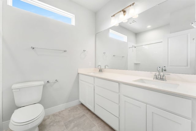 2201 Cento Walk Unit 70, Round Rock, TX 78664 - bathroom with double vanity, baseboards, a tile shower, and toilet