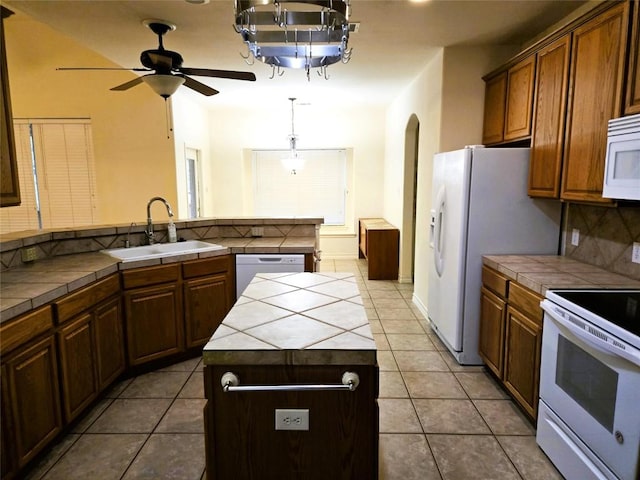 kitchen featuring tile counters, white appliances, a sink, and a ceiling fan