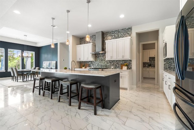 2421 High Lonesome, Leander, TX 78641 - kitchen featuring decorative backsplash, marble finish floor, refrigerator, recessed lighting, and wall chimney exhaust hood
